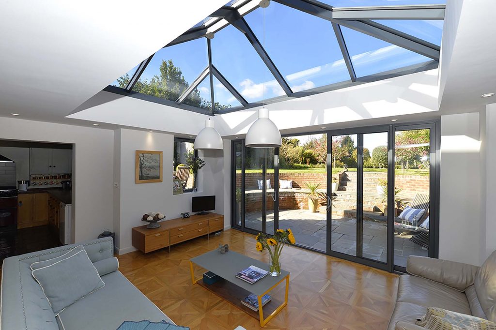 An inviting inside view of a front room featuring a stunning black lantern roof and sleek black sliding doors. The space exudes a modern and sophisticated atmosphere, providing ample natural light and a seamless indoor-outdoor connection.